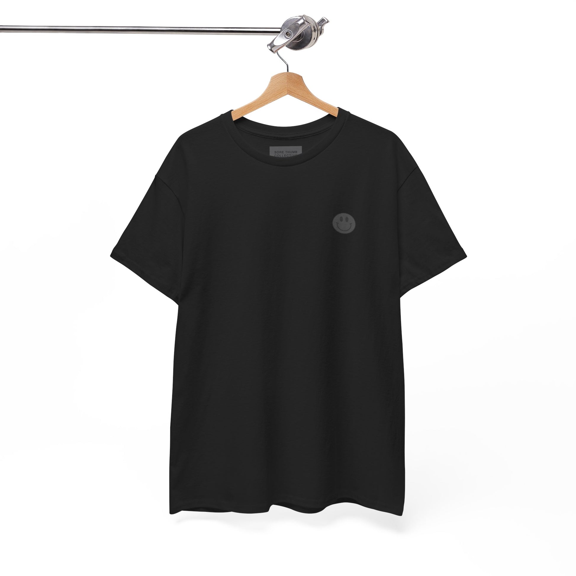 Black t-shirt with a small logo on a hanger against a white background