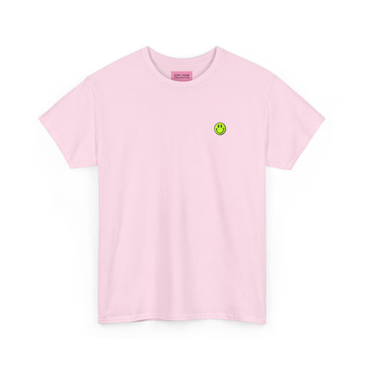 Pink t-shirt with a small green smiley face logo on a white background