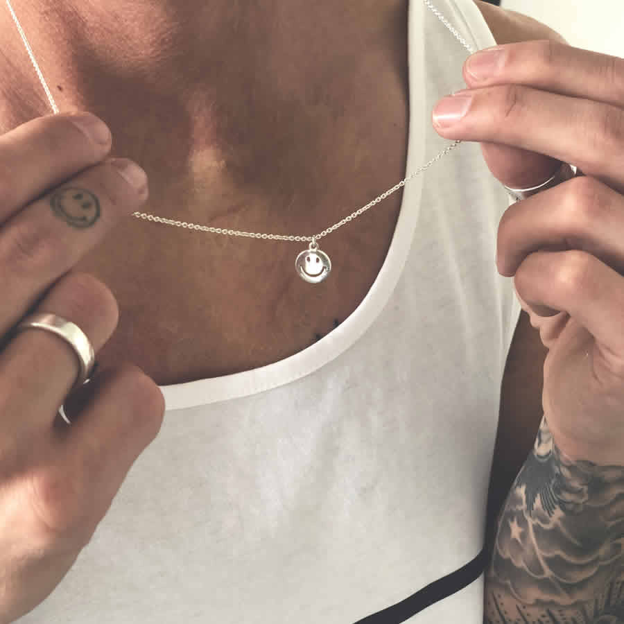 Close-up of sterling silver smiley face necklace pendant