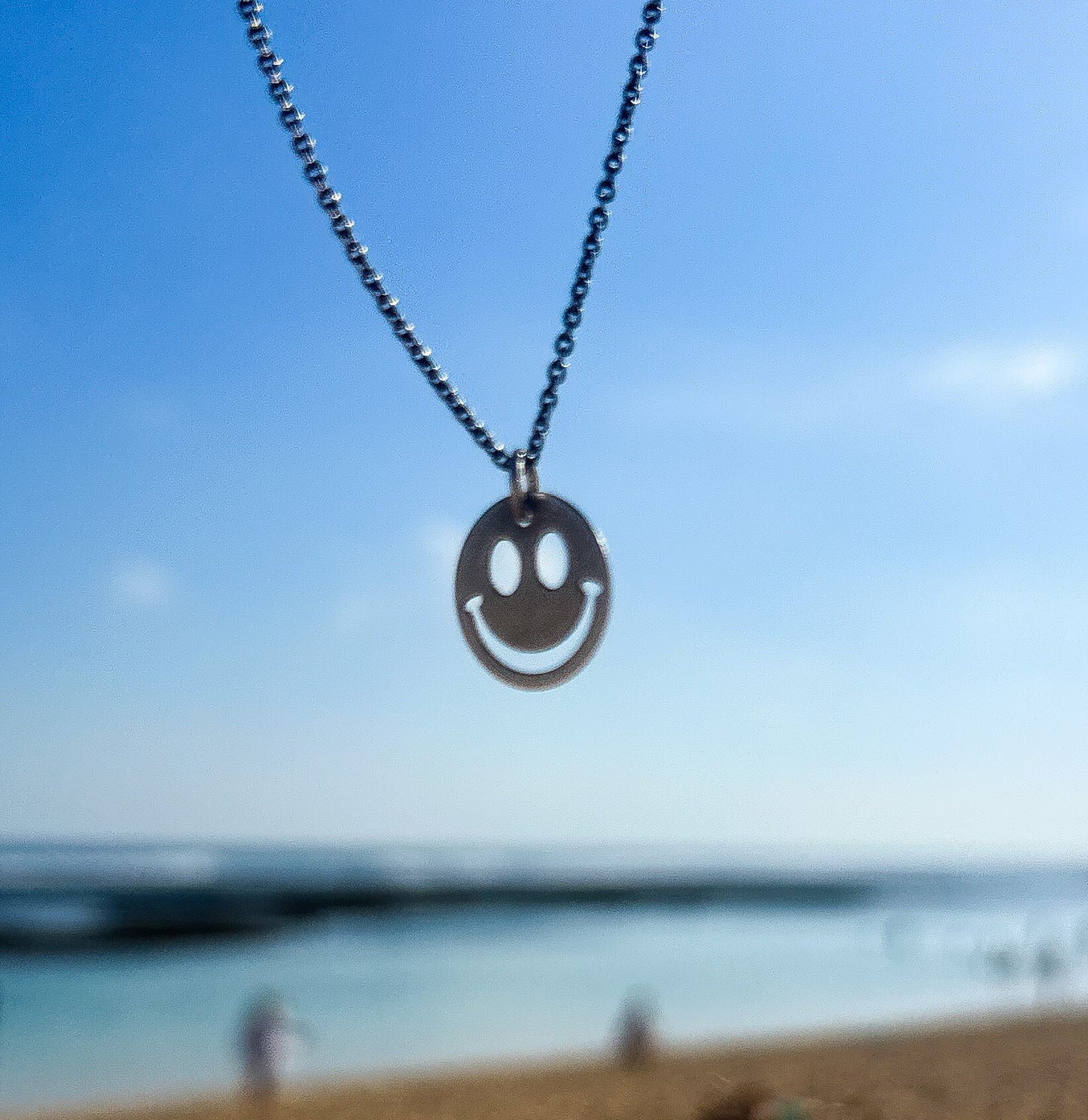 Smiley face necklace silver styled at the beach